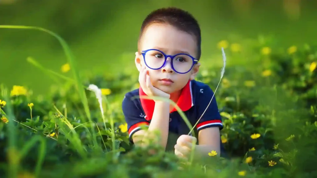 Warum Rituale für hochsensible Kinder so wichtig sind, Junge im Gras liegend
