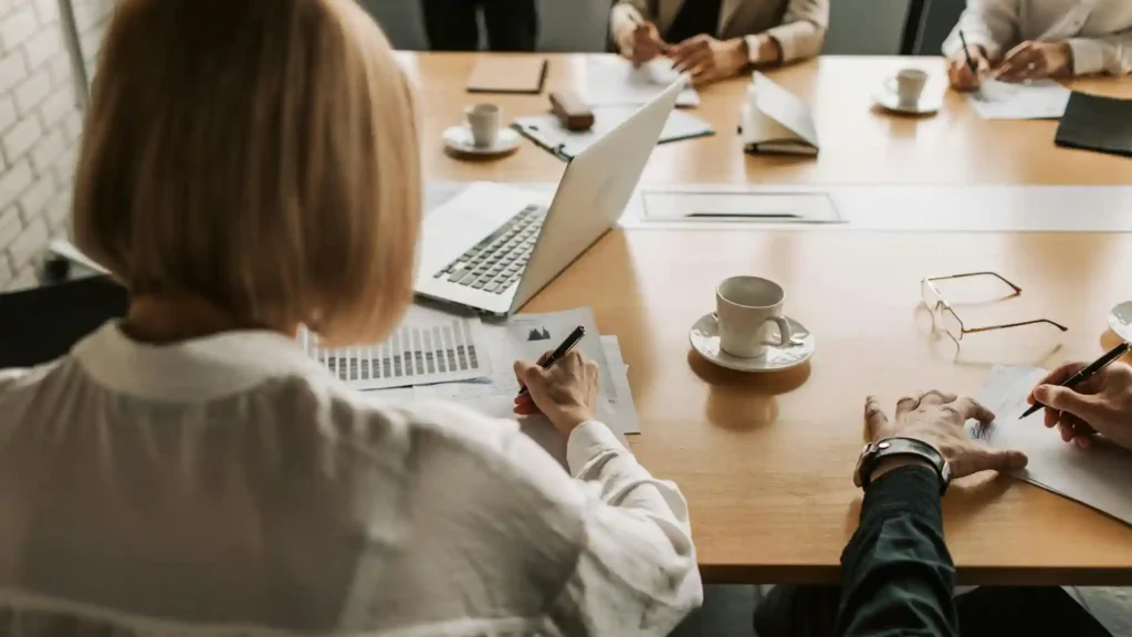 Warum Hochsensible nur eine zuhörende Rolle einnehmen, Teambesprechung am Bürotisch
