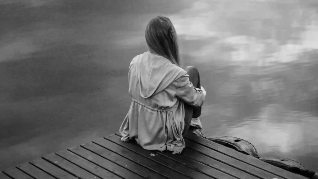 Hochsensibilität und die 40 Stunden Woche, Frau sitzt alleine am See